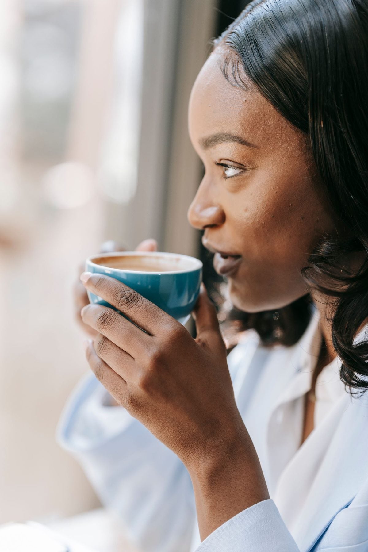 Person pausing calmly with a cup of coffee, feeling on top of their finances