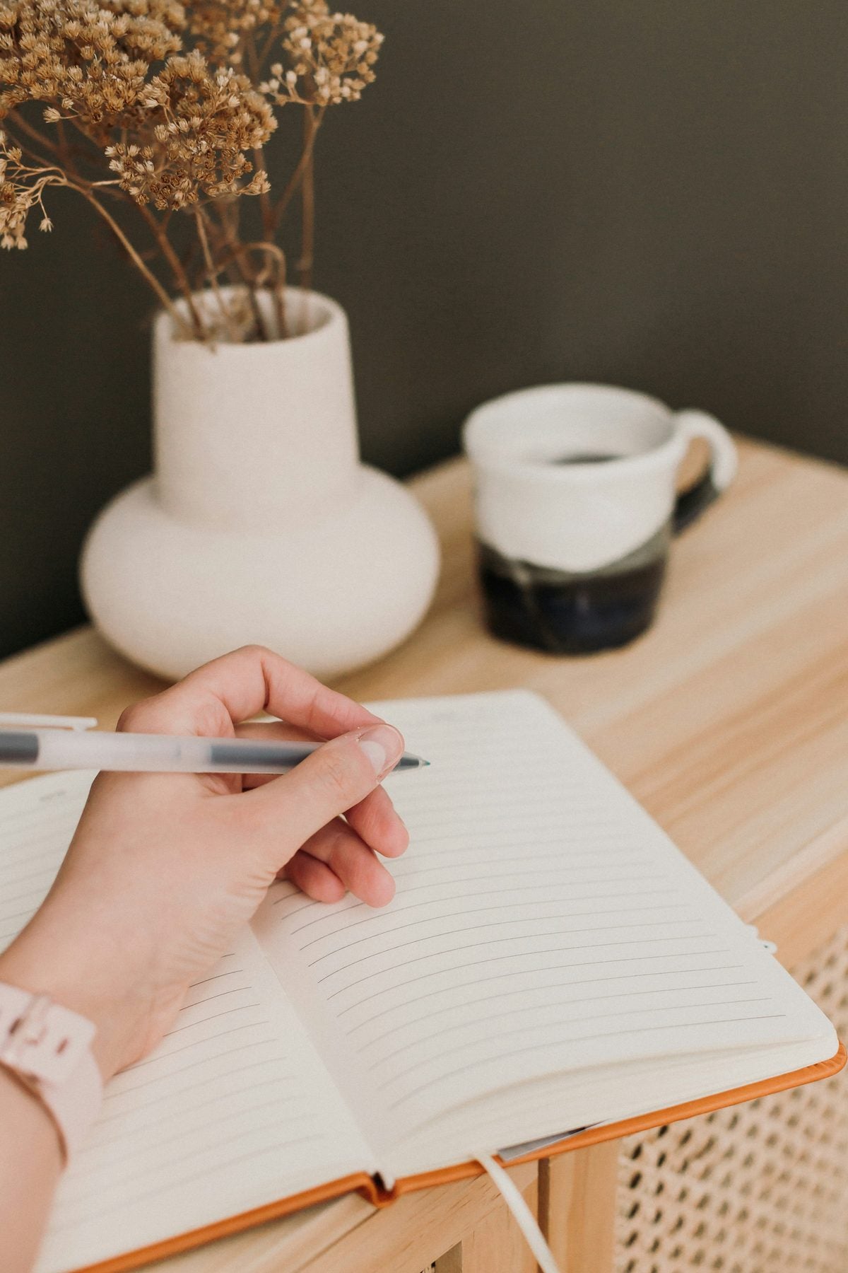 Person writing in a notebook while planning their week
