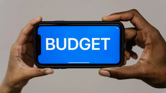 Two hands holding a smartphone displaying a budget screen