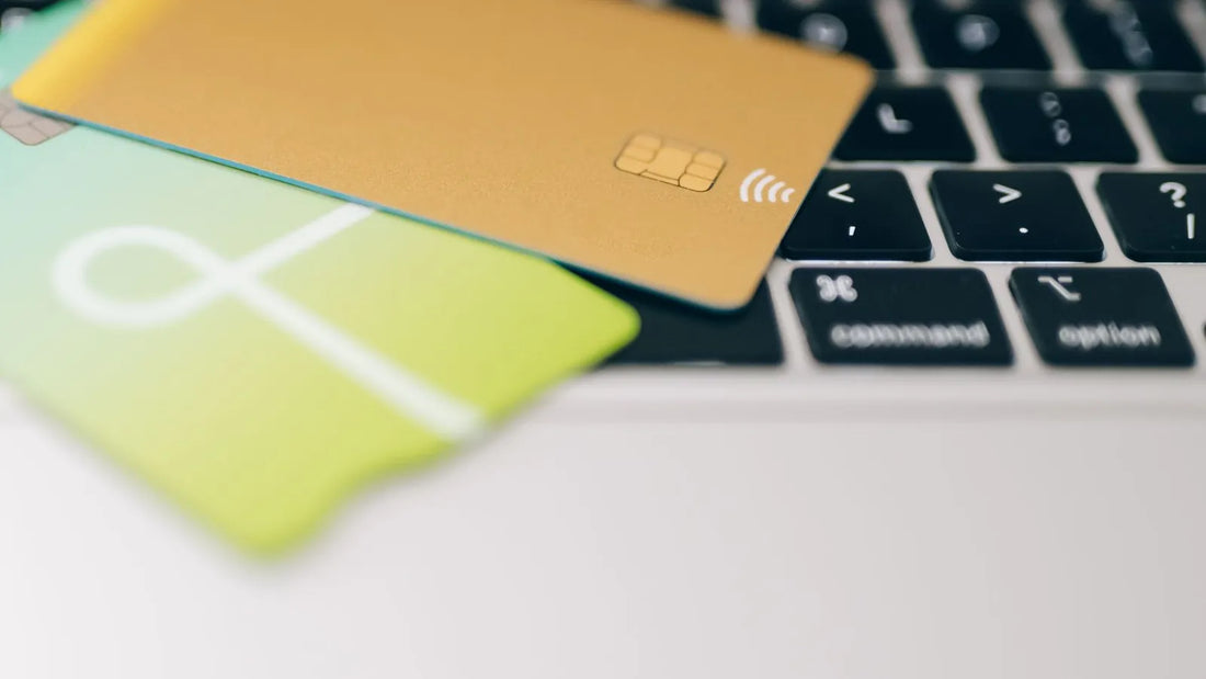 Two credit cards resting on a laptop keyboard
