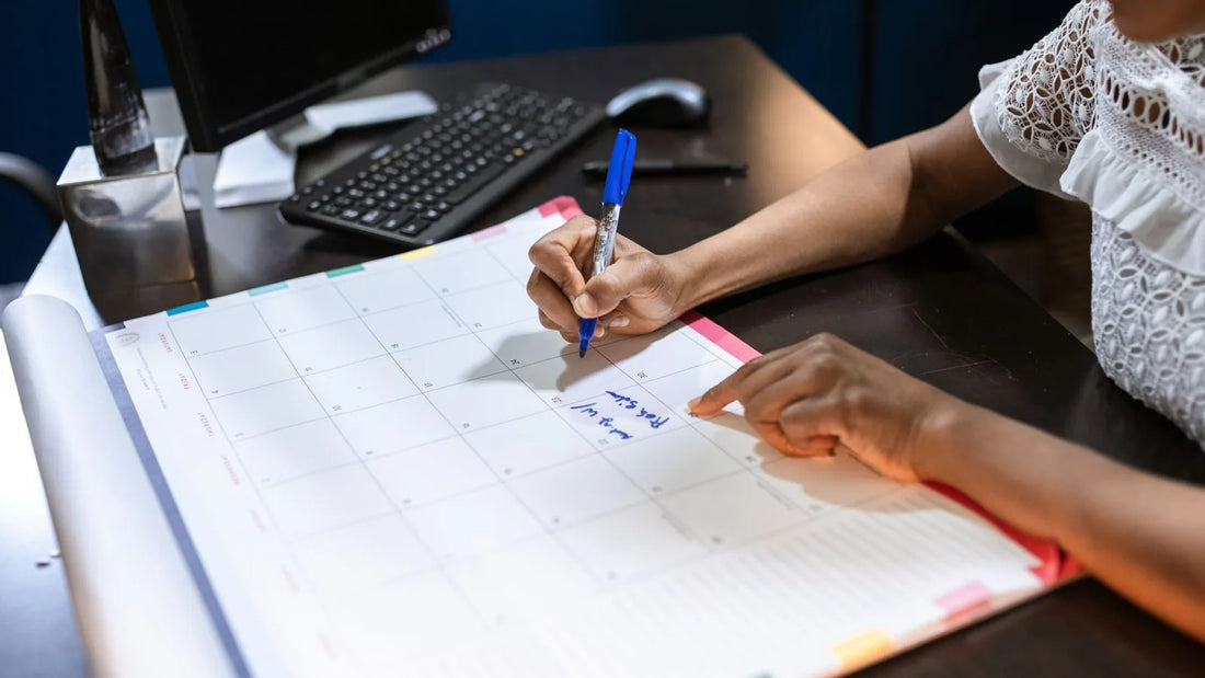Wall calendar marked with bill due dates and reminder notes for monthly bill payments