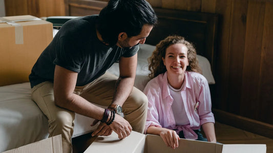 Couple unpacking cardboard boxes together in their new home