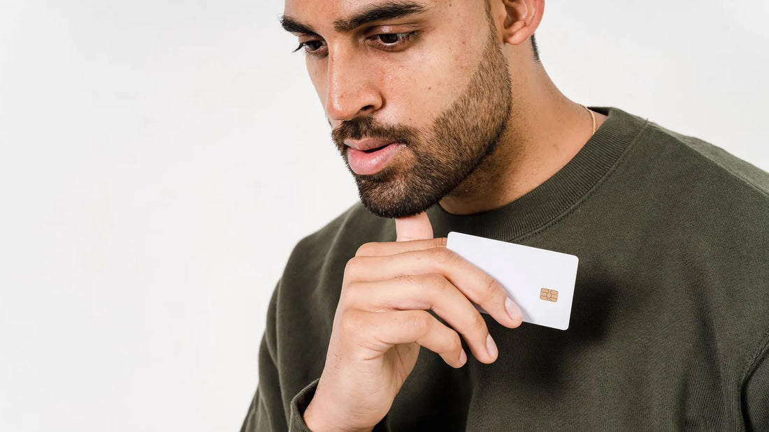 Man holding a blank credit card while deciding what to do with it