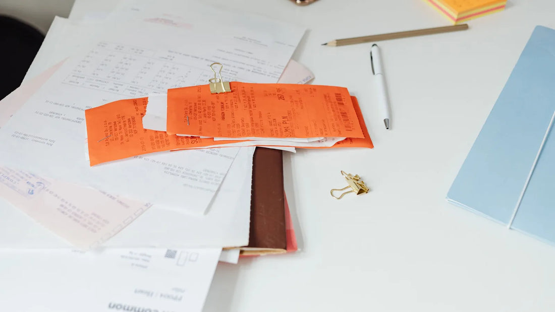 Receipts and paperwork spread across a white desk