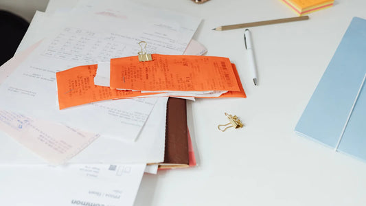 Receipts and paperwork spread across a white desk