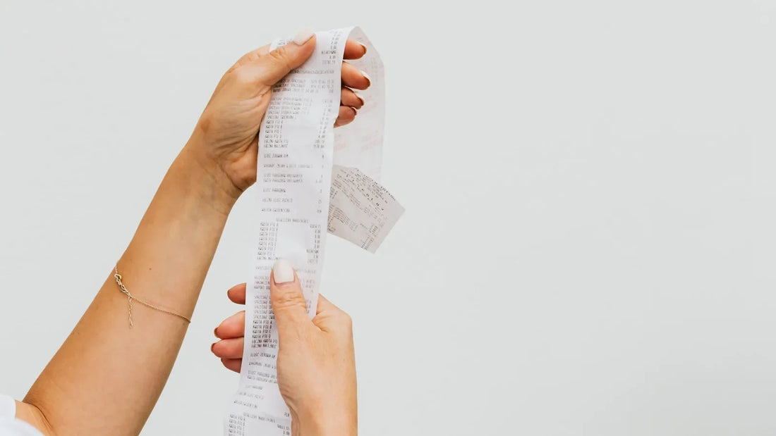 Hands holding up a long store receipt