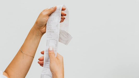 Hands holding up a long store receipt