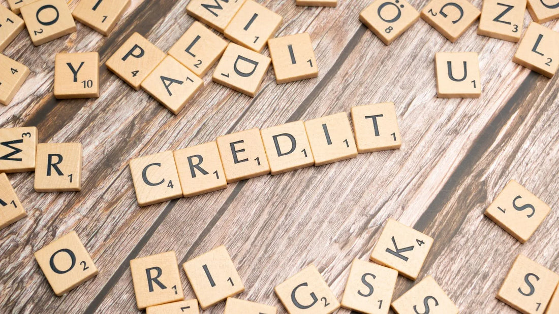 Wooden letter tiles spelling the word "credit" on a rustic wooden surface
