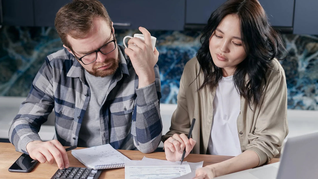 Couple sitting together reviewing bills and a budget at their kitchen table