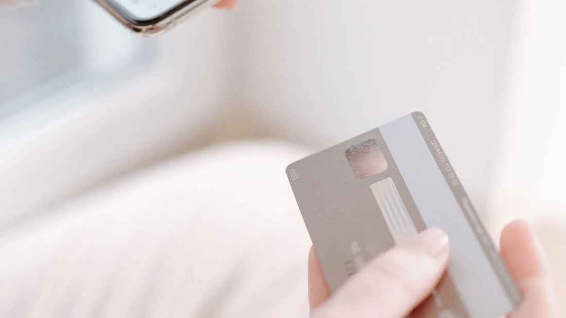 Hands holding a smartphone and a credit card together