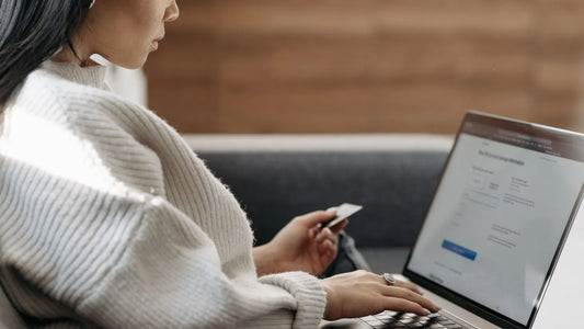 Woman entering credit card details on a laptop to make a payment