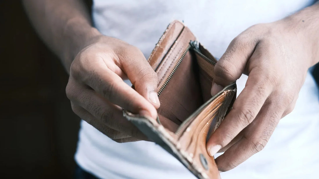Close-up of hands opening an empty leather wallet