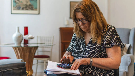 Woman at home working out her monthly budget with a calculator and a notebook