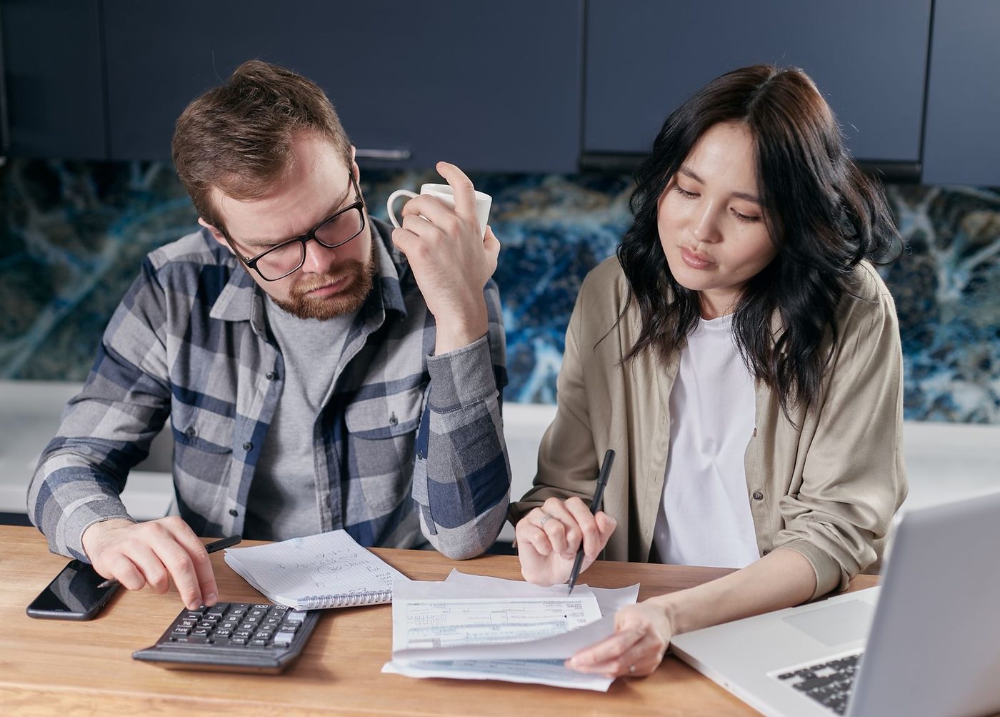 Couple reviewing household bills together at the kitchen table