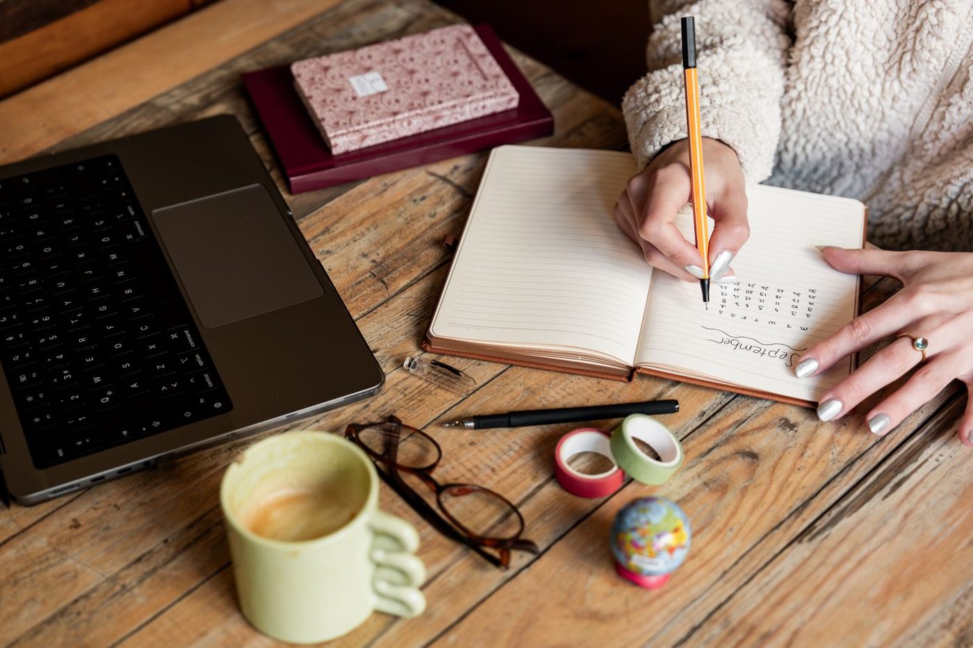 Planner, notebook, and laptop on a desk during a daily planning routine